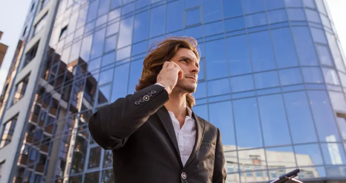 Hombre pasando delante de una fachada de cristal de una edificio